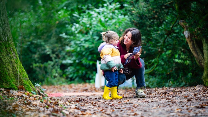 A young woman and a small child smile as they enjoy time together on the Albana walk